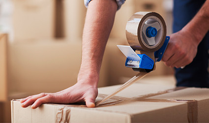 Moving And Packing Tips From Long Island Moving Experts taping a moving box